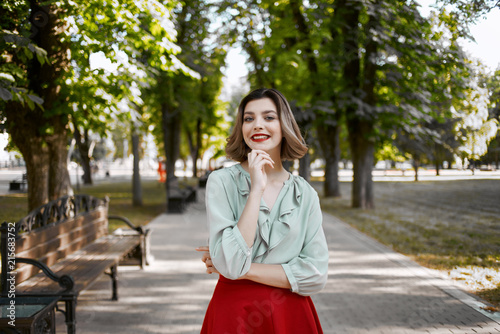 a woman in a red skirt walks in the park © SHOTPRIME STUDIO