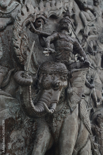 The demon army over Elephant Thai style Teak wood carving at Wat Traimitr (Thai Temple) Bangkok,Thailand