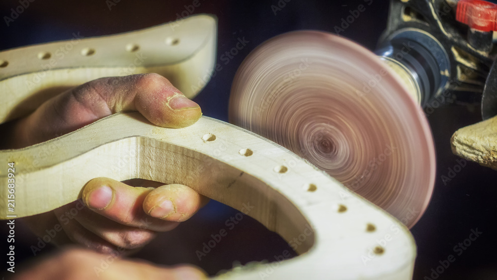 A large plan, hands of an artisan working on a wooden part