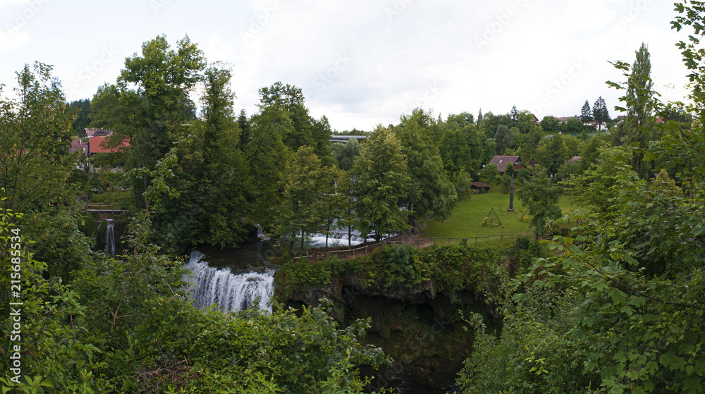 Fototapeta premium Croazia, 26/06/2018: vista panoramica di Rastoke, il centro storico del comune di Slunj, con le sue case di legno, gli antichi mulini ad acqua e le cascate nel fiume Korana