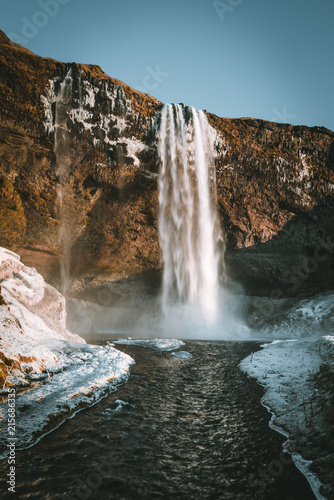 Wonderful landscape from Seljalandsfoss Waterfall in Iceland on a clear day with blue sky and snow.