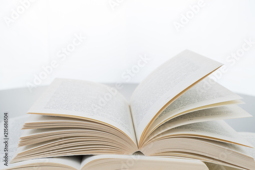 Stack of open books lying on grey table