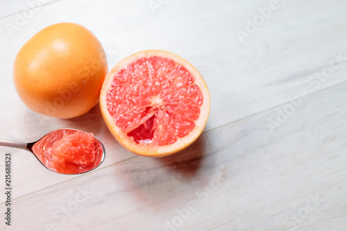 Grapefruit with spoon on a wood table. Close-up.