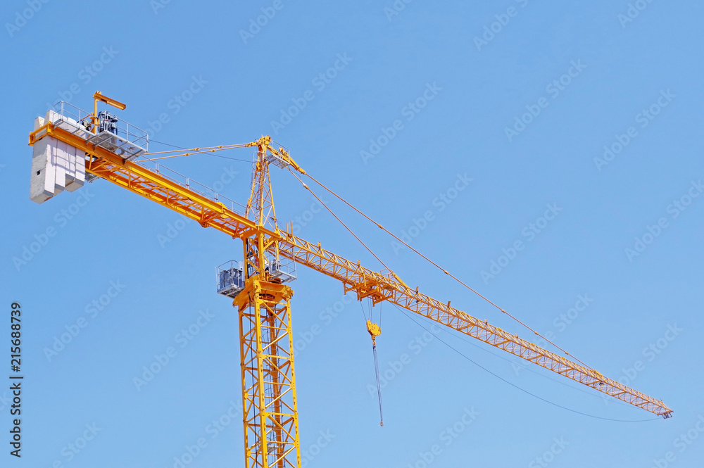 yellow construction crane tower on background of blue sky