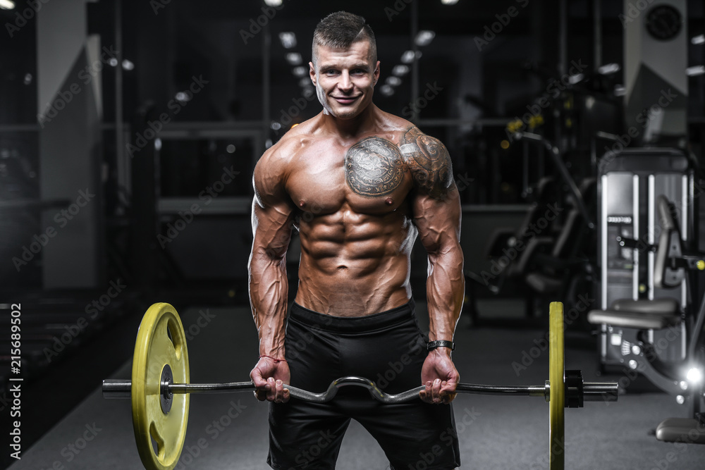 Handsome strong bodybuilder athletic men pumping up muscles with dumbbells Handsome strong bodybuilder athletic men pumping up muscles with dumbbells