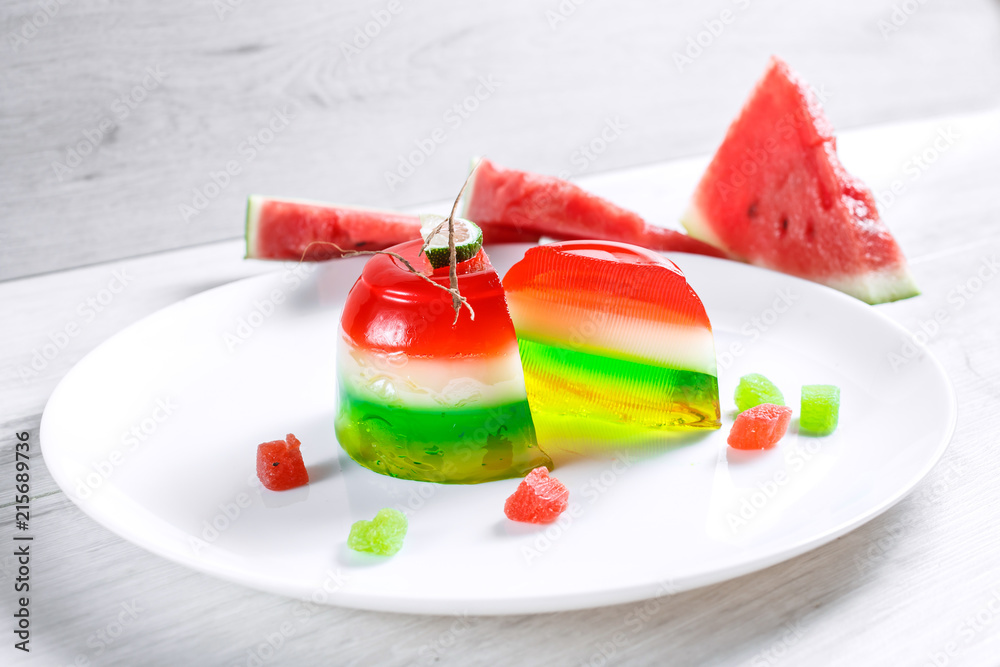 Watermelon dessert. Panakota and jelly in a white plate on the table background. Top view Watermelon dessert. Panakota and jelly in a white plate on the table background. Top view