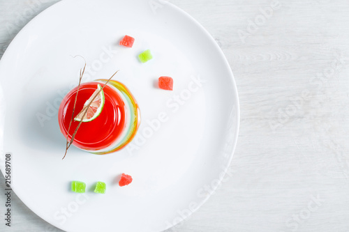 Watermelon dessert. Panakota and jelly in a white plate on the table background. Top view