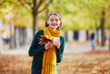 Happy young girl in yellow scarf walking in autumn park