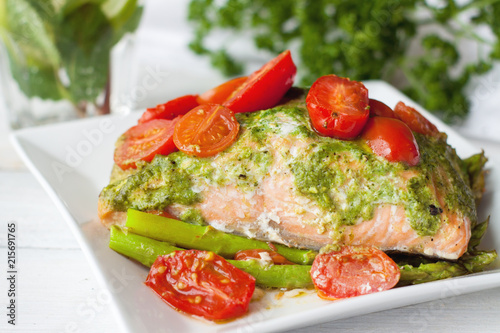 Salmon baked in foil with pesto, tomatoes, asparagus