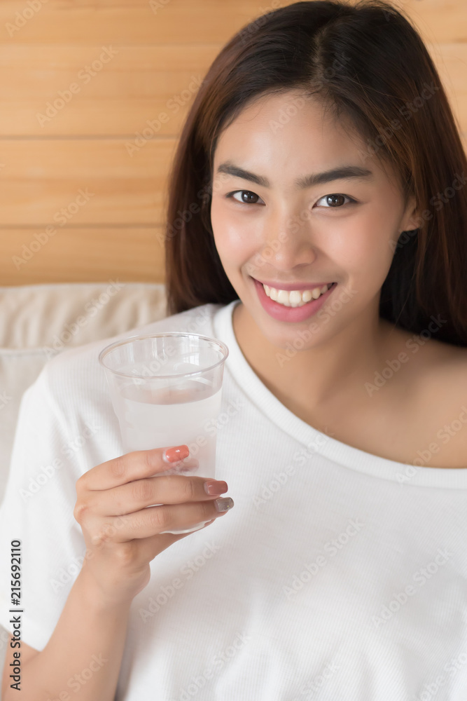 happy, smiling woman drinking fresh cold water; health related water intake, body hydration concept; young adult asian persian woman or asian middle east woman model happy, smiling woman drinking fresh cold water; health related water intake, body hydration concept; young adult asian persian woman or asian middle east woman model