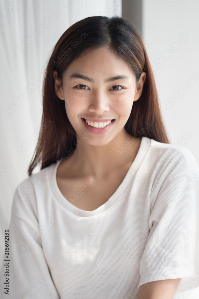 happy smiling girl; portrait of positive relaxed happy smiling asian woman smiles in indoor home environment; young adult asian persian woman or asian middle east woman model happy smiling girl; portrait of positive relaxed happy smiling asian woman smiles in indoor home environment; young adult asian persian woman or asian middle east woman model