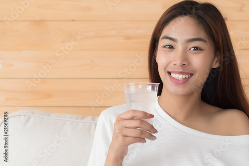 happy, smiling woman drinking fresh cold water; health related water intake, body hydration concept; young adult asian persian woman or asian middle east woman model
