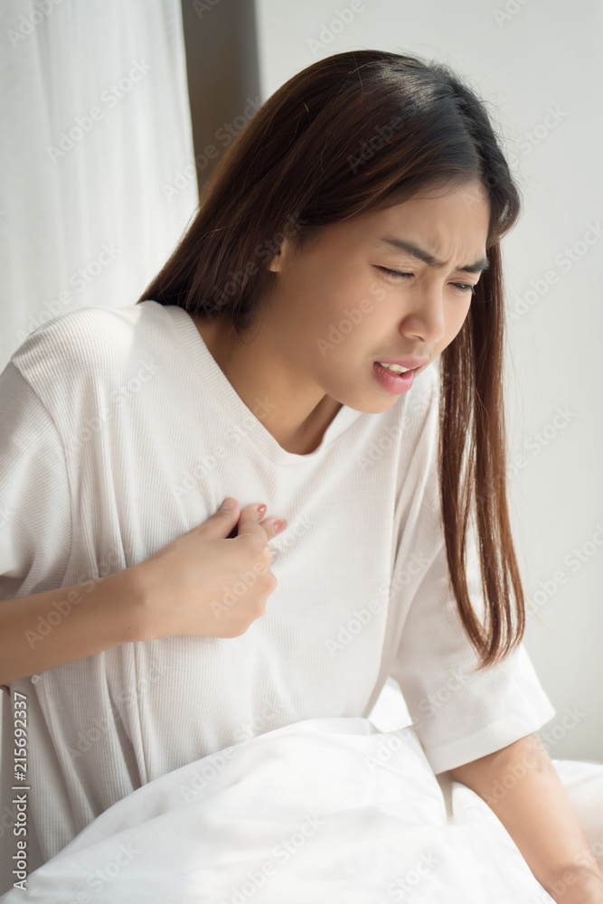 sick woman with indigestion problem, acid reflux or gerd symptoms; woman health care, body care, sickness, pain, acid reflux concept; asian middle east 20s adult, mixed race woman model sick woman with indigestion problem, acid reflux or gerd symptoms; woman health care, body care, sickness, pain, acid reflux concept; asian middle east 20s adult, mixed race woman model