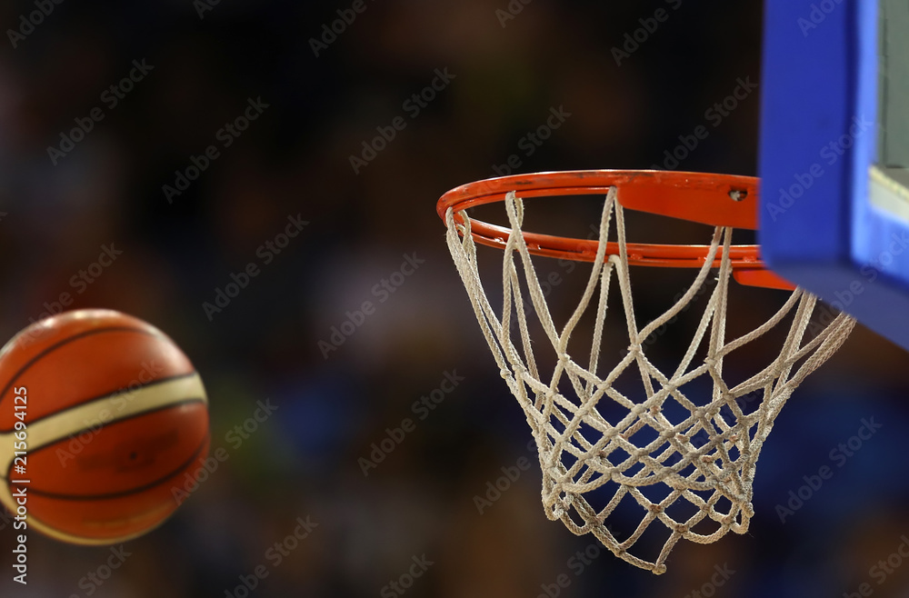 Fototapeta premium Basketball ball flies towards the basketball hoop on the background of the stands