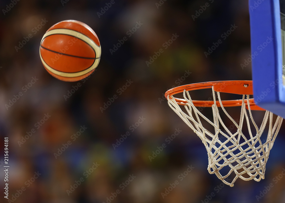 Naklejka premium Basketball ball flies towards the basketball hoop on the background of the stands