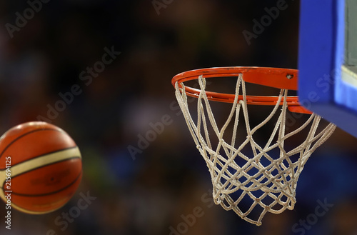 Basketball ball flies towards the basketball hoop on the background of the stands photo