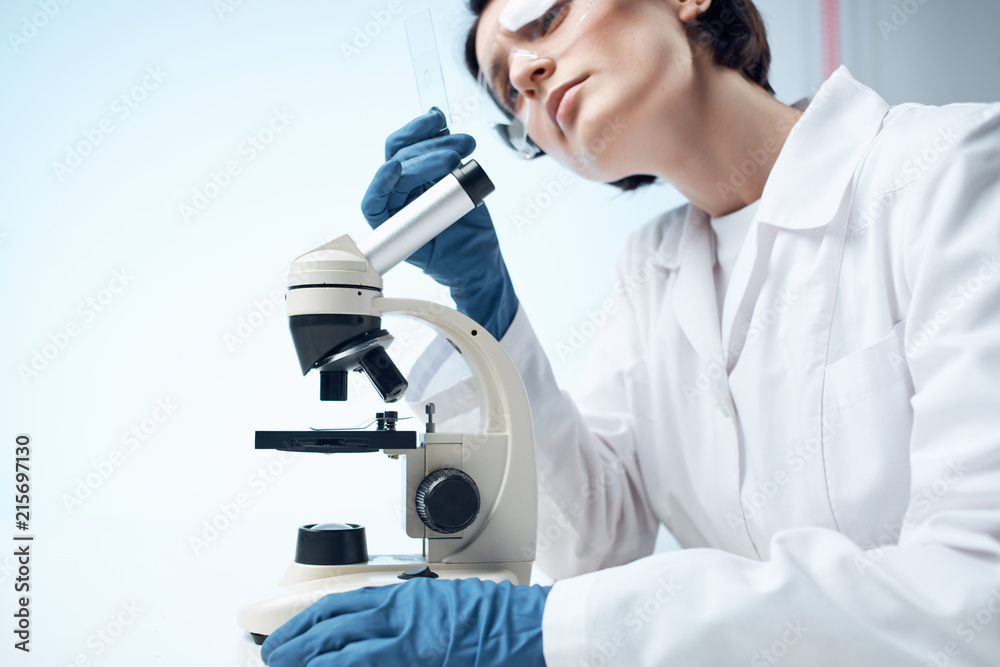 laboratory technician looking through a microscope laboratory technician looking through a microscope