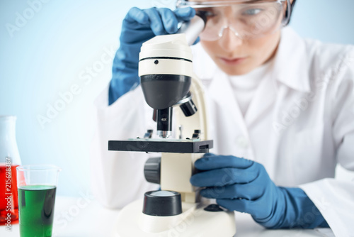 scientist looking through microscope