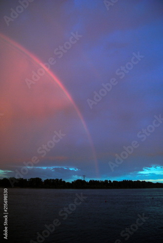 Fototapeta Naklejka Na Ścianę i Meble -  rainbow at sunset over the river