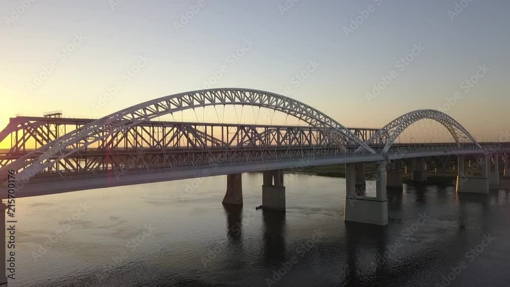 arched bridge at sunset. Cars are driving on a bridge. urban traffic. Video from the quadro. Dron, view from the top. arched bridge at sunset. Cars are driving on a bridge. urban traffic. Video from the quadro. Dron, view from the top.