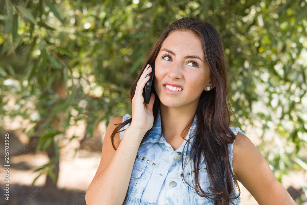 Unhappy, Confused Mixed Race Young Female Talking on Cell Phone Outside Unhappy, Confused Mixed Race Young Female Talking on Cell Phone Outside