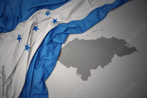 waving colorful national flag and map of honduras.