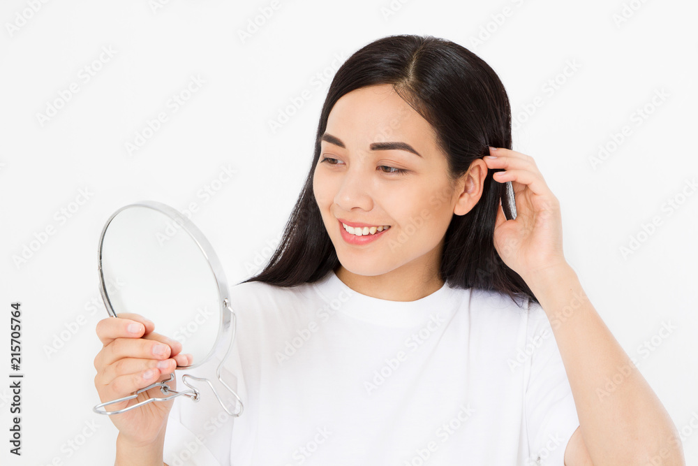 Young asian woman looking in mirror isolated on white background. Copy space. Skin care and anti aging collagen concept. Macro perfect korean girl face. Young asian woman looking in mirror isolated on white background. Copy space. Skin care and anti aging collagen concept. Macro perfect korean girl face.