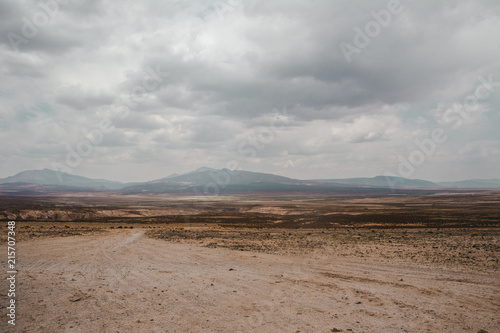 Farmland and hazy mountains in the distance of the arid landscape of southern Bolivia