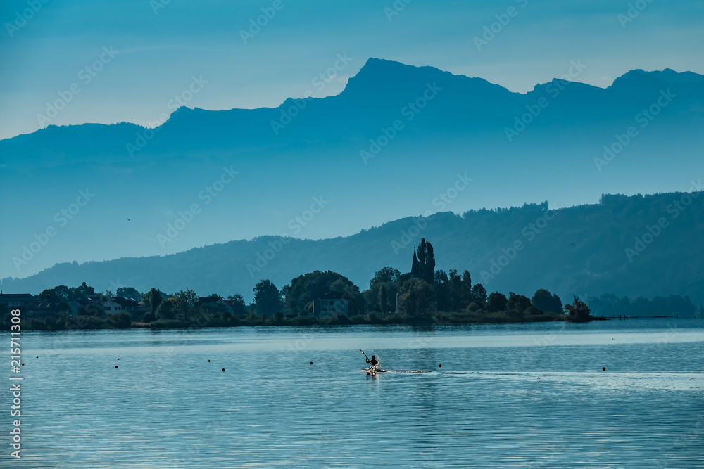 Water sports on the shores of the Upper Zurich Lake, near the historical village of BussKirch, Rapperswil-Jona, Sankt Gallen, Swizerland Water sports on the shores of the Upper Zurich Lake, near the historical village of BussKirch, Rapperswil-Jona, Sankt Gallen, Swizerland