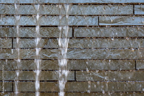 Stone wall water feature, with blurred water and rock bricks, as a background