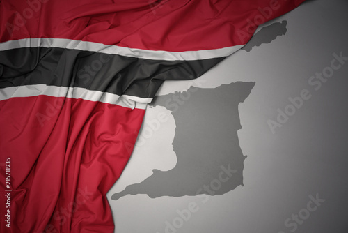 waving colorful national flag and map of trinidad and tobago.