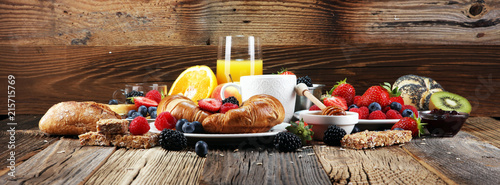 Fotografia breakfast on table with waffles, croissants, coffe and juice.