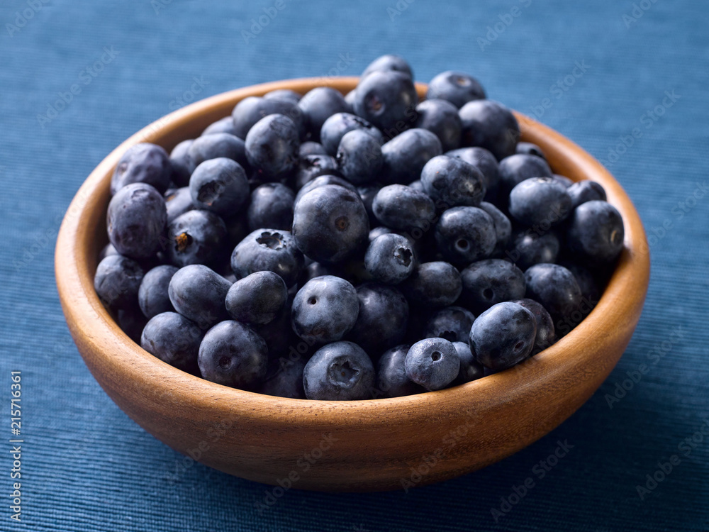 Closeup of fresh blueberries in a wooden plate Closeup of fresh blueberries in a wooden plate