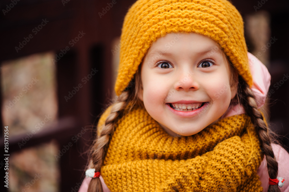 autumn close up portrait of happy little child girl enjoying the walk in sunny park in warm knitted hat and scarf autumn close up portrait of happy little child girl enjoying the walk in sunny park in warm knitted hat and scarf