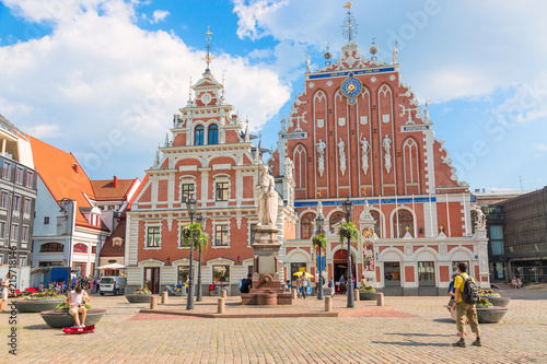 View of the Old Town square, Roland Statue, The Blackheads House near St Peters Cathedral against blue sky in Riga, Latvia. Summer sunny day