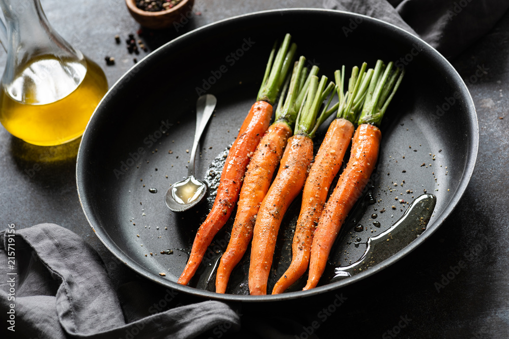 Cooking carrots. Fresh carrots ready for cooking on a pan. Roast carrots with olive oil and honey Cooking carrots. Fresh carrots ready for cooking on a pan. Roast carrots with olive oil and honey