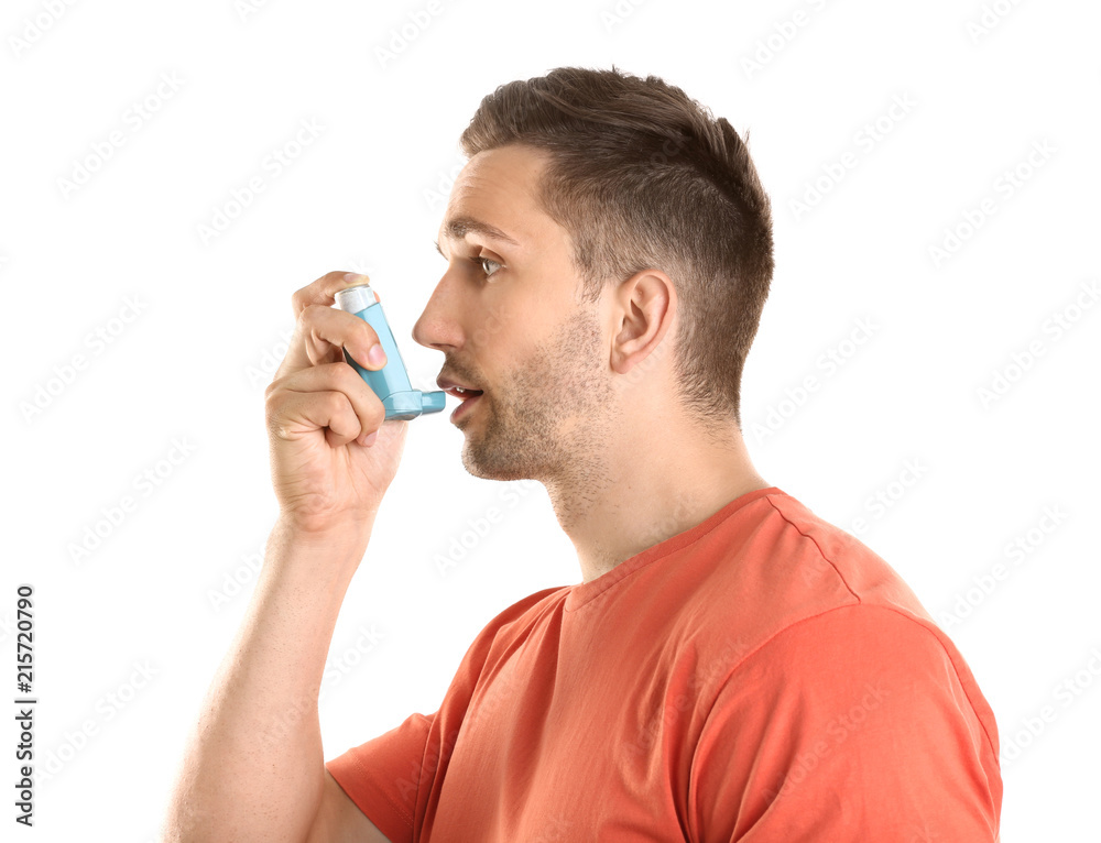 Young man with asthma using inhaler on white background Young man with asthma using inhaler on white background