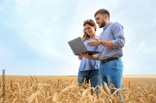 Young agronomists in grain field. Cereal farming photo