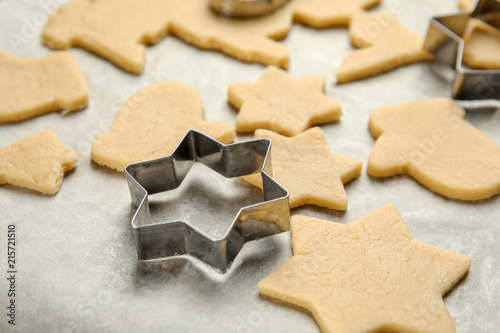 Raw Christmas cookies and cutters on baking parchment