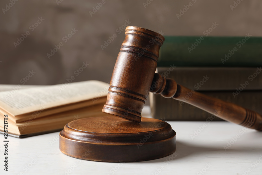 Wooden gavel and books on table against color background, closeup. Law concept Wooden gavel and books on table against color background, closeup. Law concept
