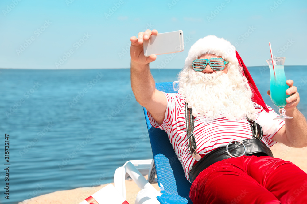 Obraz premium Authentic Santa Claus taking selfie at resort