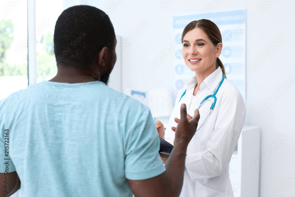 Young doctor speaking to African-American patient in hospital