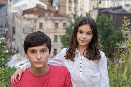 beautiful children, brother and sister (boy and girl). stand against the background of the old city