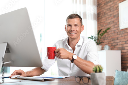фотографія Young man working with computer in home office