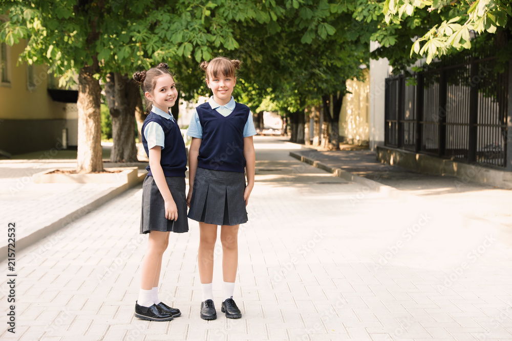 Little girls in stylish school uniform outdoors Little girls in stylish school uniform outdoors
