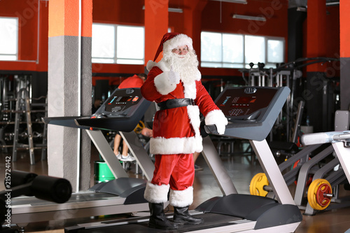Authentic Santa Claus training on treadmill in modern gym