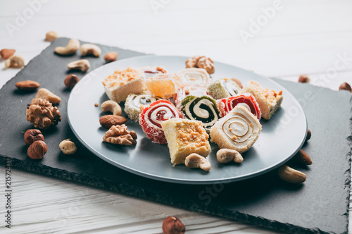 Bilde på lerret Traditional oriental sweets and nuts: hazelnuts, cashews on a white wooden background