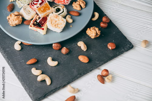 Bilde på lerret Traditional oriental sweets and nuts: hazelnuts, cashews on a white wooden background