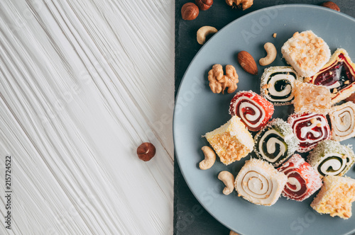 Bilde på lerret Traditional oriental sweets and nuts: hazelnuts, cashews on a white wooden background