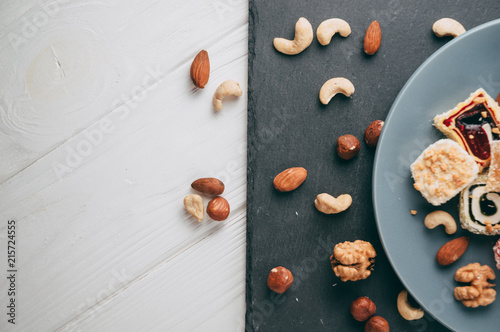 Bilde på lerret Traditional oriental sweets and nuts: hazelnuts, cashews on a white wooden background